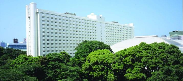 a large white building surrounded by trees and buildings.