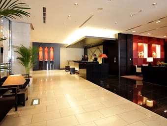 Elegant hotel lobby with reception desk and decorative lighting.