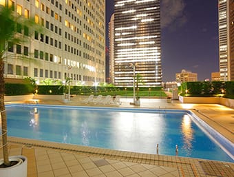 a large swimming pool in a city at night.