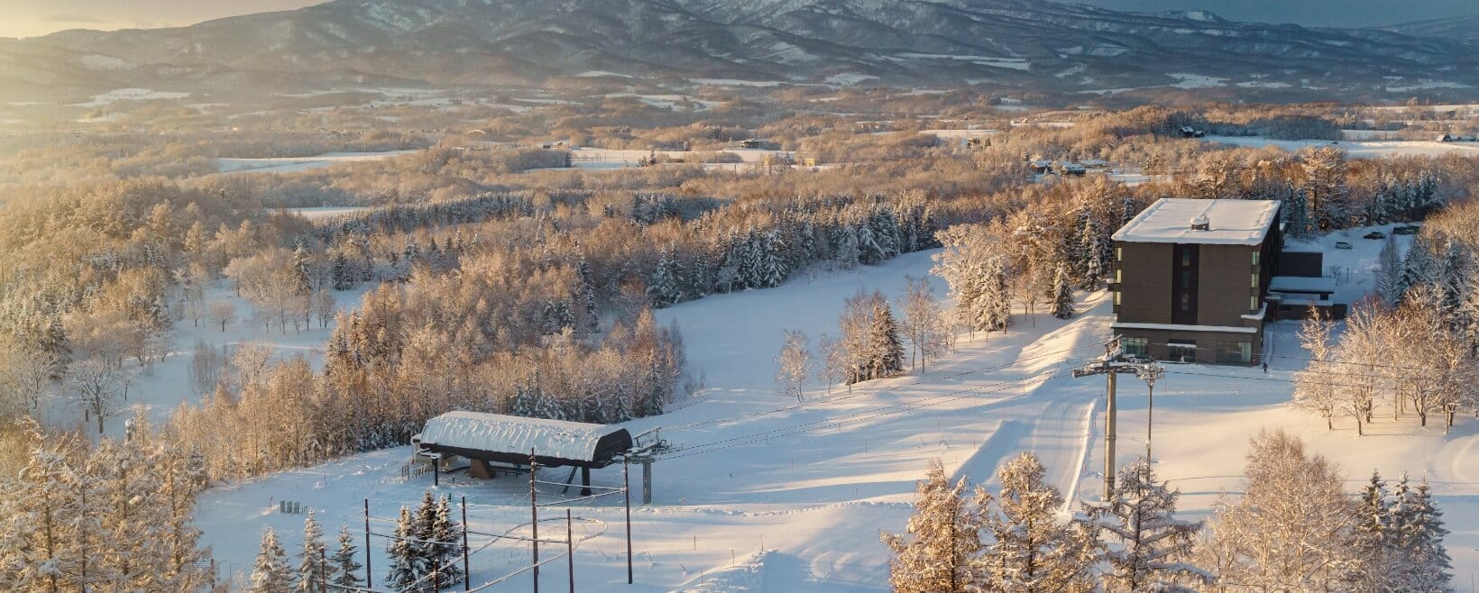 a small cabin in the middle of a snowy field.