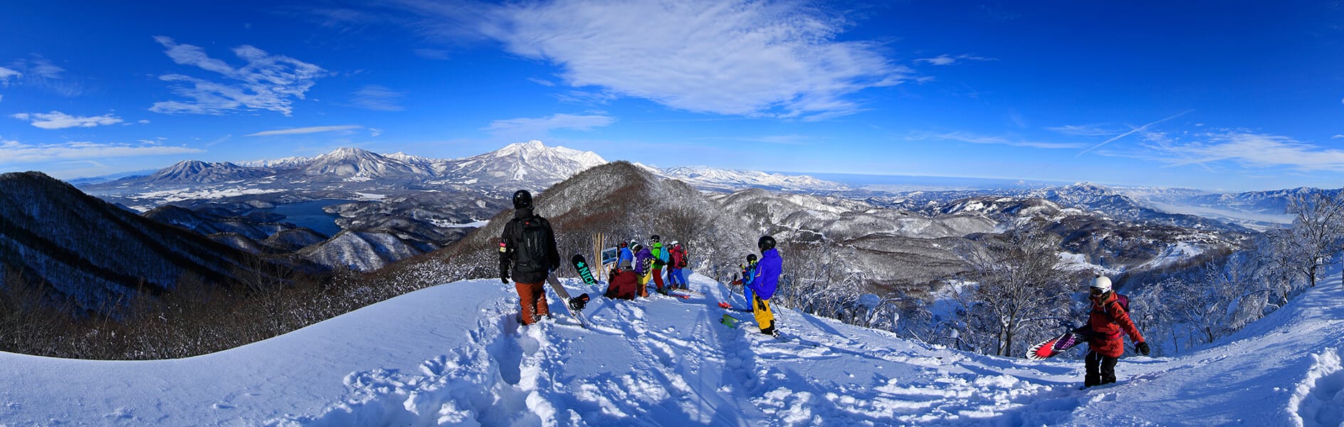 a group of people standing on top of a snow covered slope.
