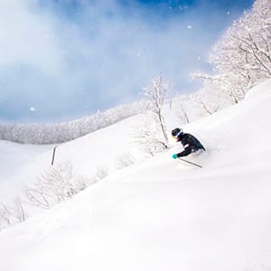 a man riding skis down a snow covered slope.